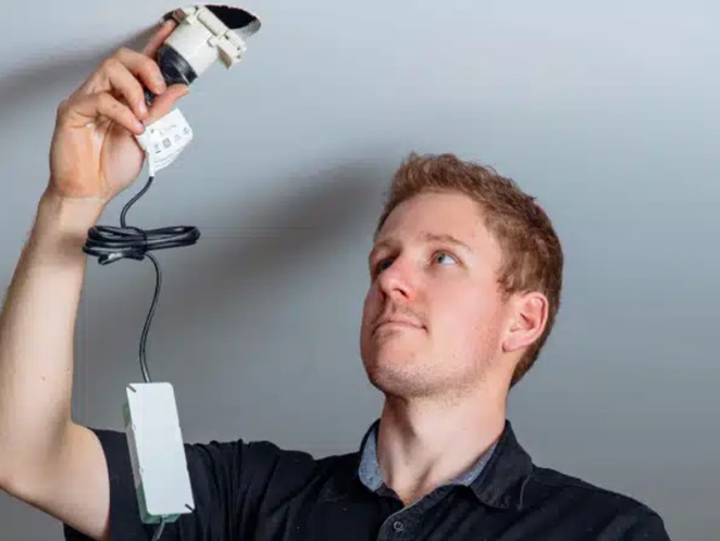 Two colleagues in the office looking at a laptop screen with a smile