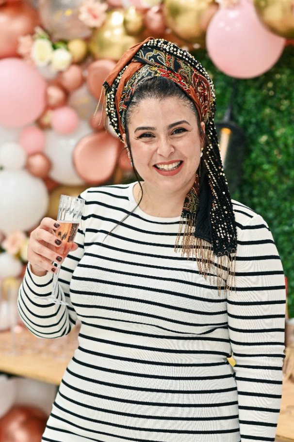 אישה מחייכת עם כוס יין ביד