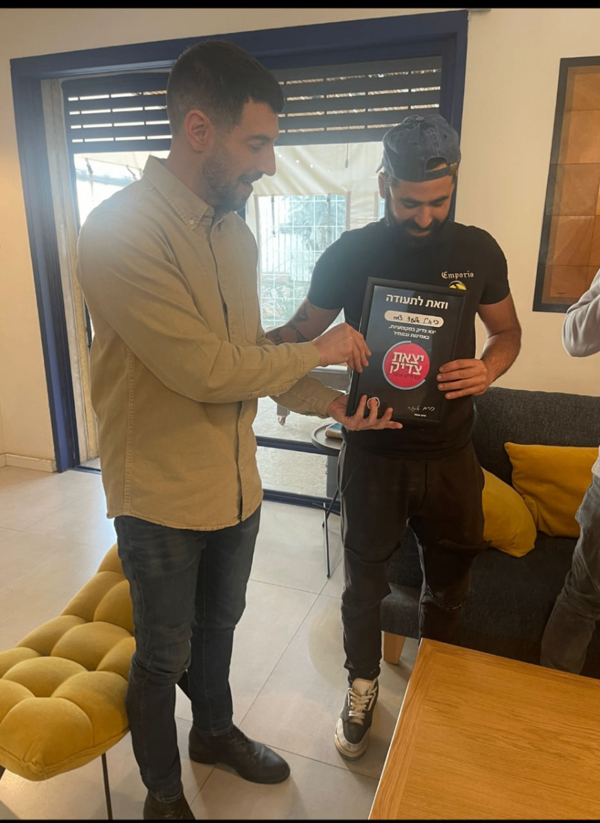 שני עמיתים במשרד מסתכלים על מסך של לפטופ בחיוך