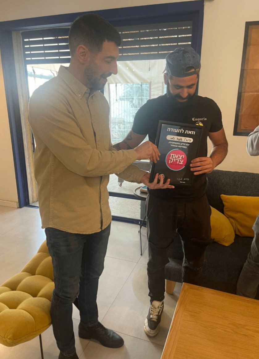 שני עמיתים במשרד מסתכלים על מסך של לפטופ בחיוך