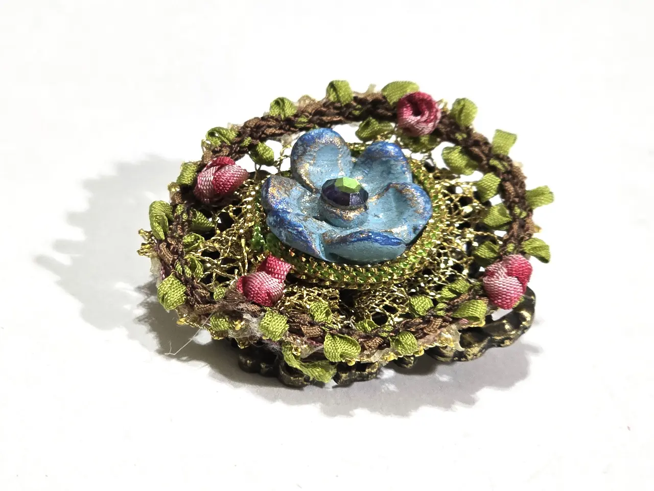 סיכה נדירה של מיכל נגרין חתומה מאחור שזור בחוטי זהב שבתוכם ורדים ובמאכז פרח כחול עם אבן סברובסקי ירוקה