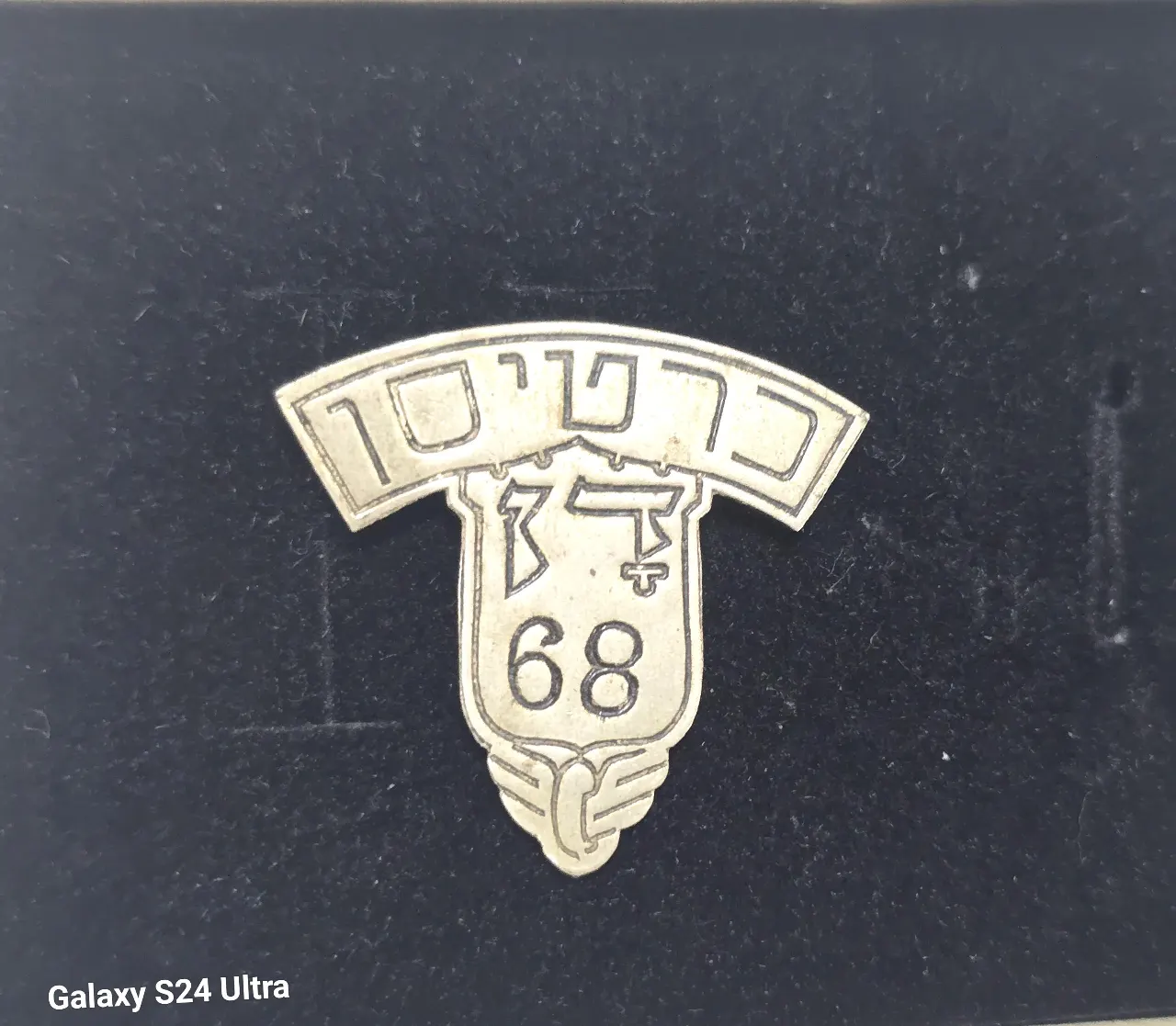 סמל כובע מוקדם כרטיסן בחברת האוטובוסים דן משנות ה-40. פלדה. מספר 68. מידות כ 32x32 מ״מ