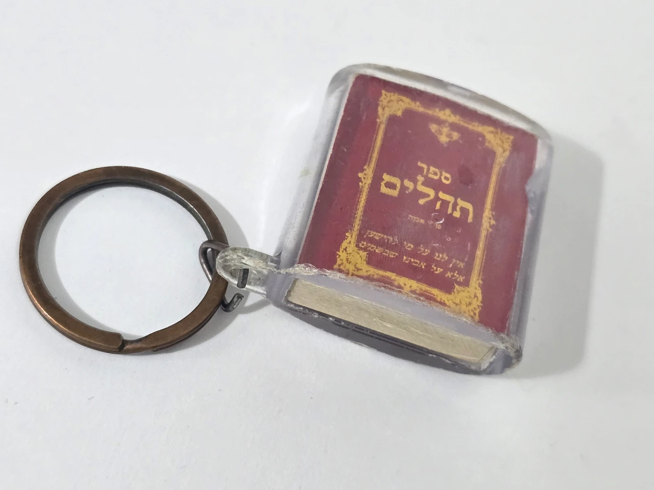 מחזיק מפתחות עם ספר תהילים מונח בקופסת פלסטיק