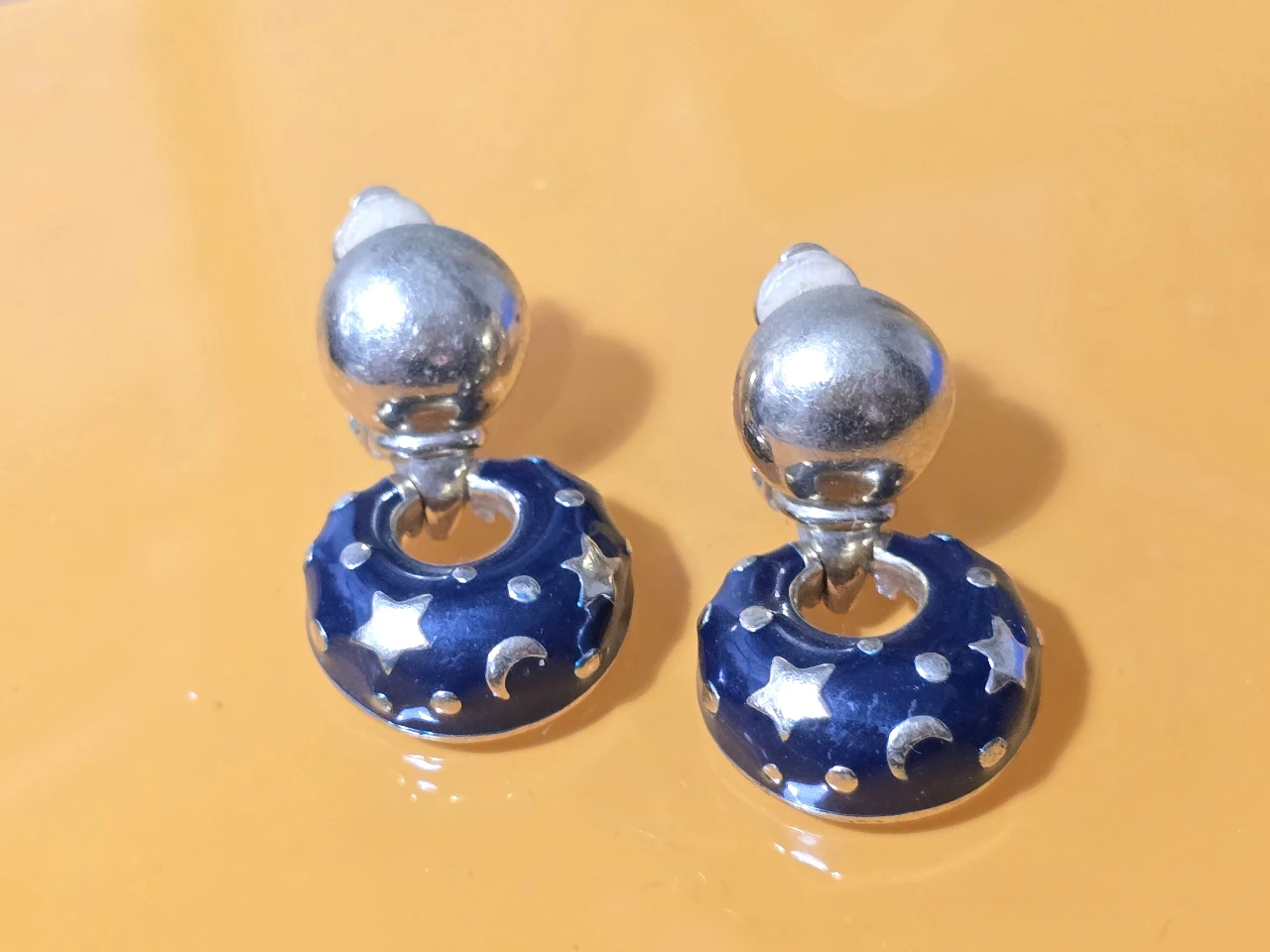 עגילי קליפס וינט'ג עם עיצוב נושאי ירח וכוכבים העגילים ממתכת בגימור זהב ושילוב של אמייל כחול