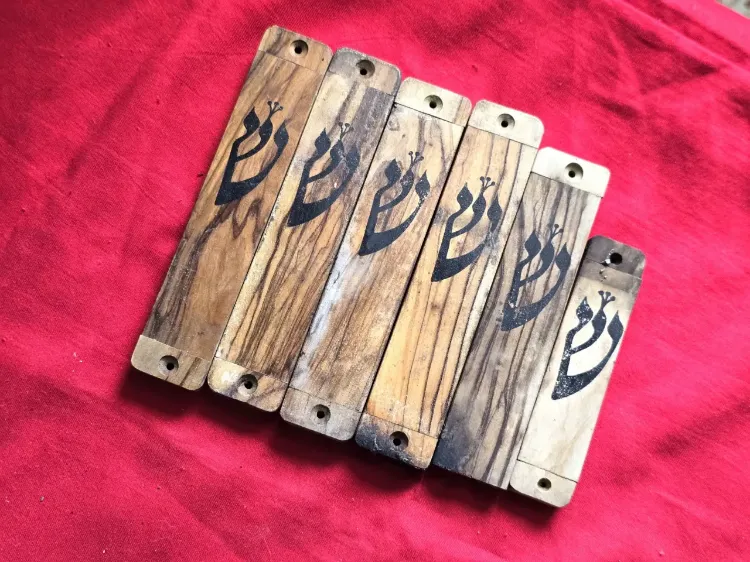 6 בתי מזוזה ישנים, עשויים עץ זית, אות ש' מודגשת בצבע שחור.   כנראה שנות ה-30-40 , ארץ ישראל.   מידות -   4 בתי מזוזה - 14.5X3 סמ   1 בית מזוזה - 13X3 סמ   1 בית מזוזה - 10.5X2.5 סמ.   מצב שמור , סימני גיל .