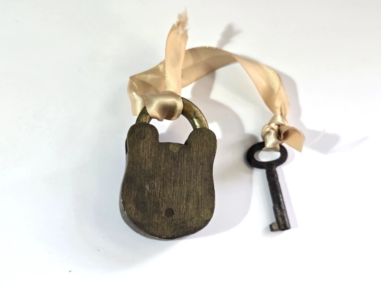 מנעול תליה עתיק עשוי פליז בעל מנגנון מכני על המנעול כתוב SECURE 4 LEVER המספר 4 מציין את מספר המנופים בתוך המנעול