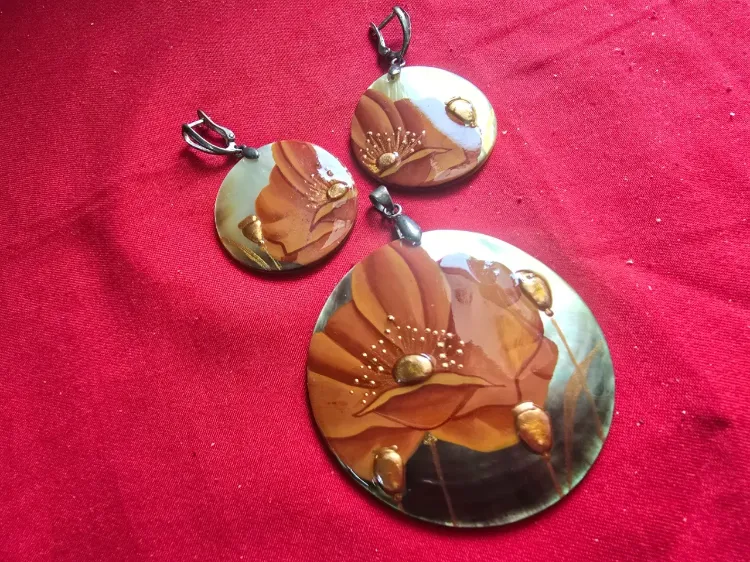 סט של תליון עגול וגדולבנוסף זוג עגילים תואם עשויים מאם הפנינה ובחזית אמייל