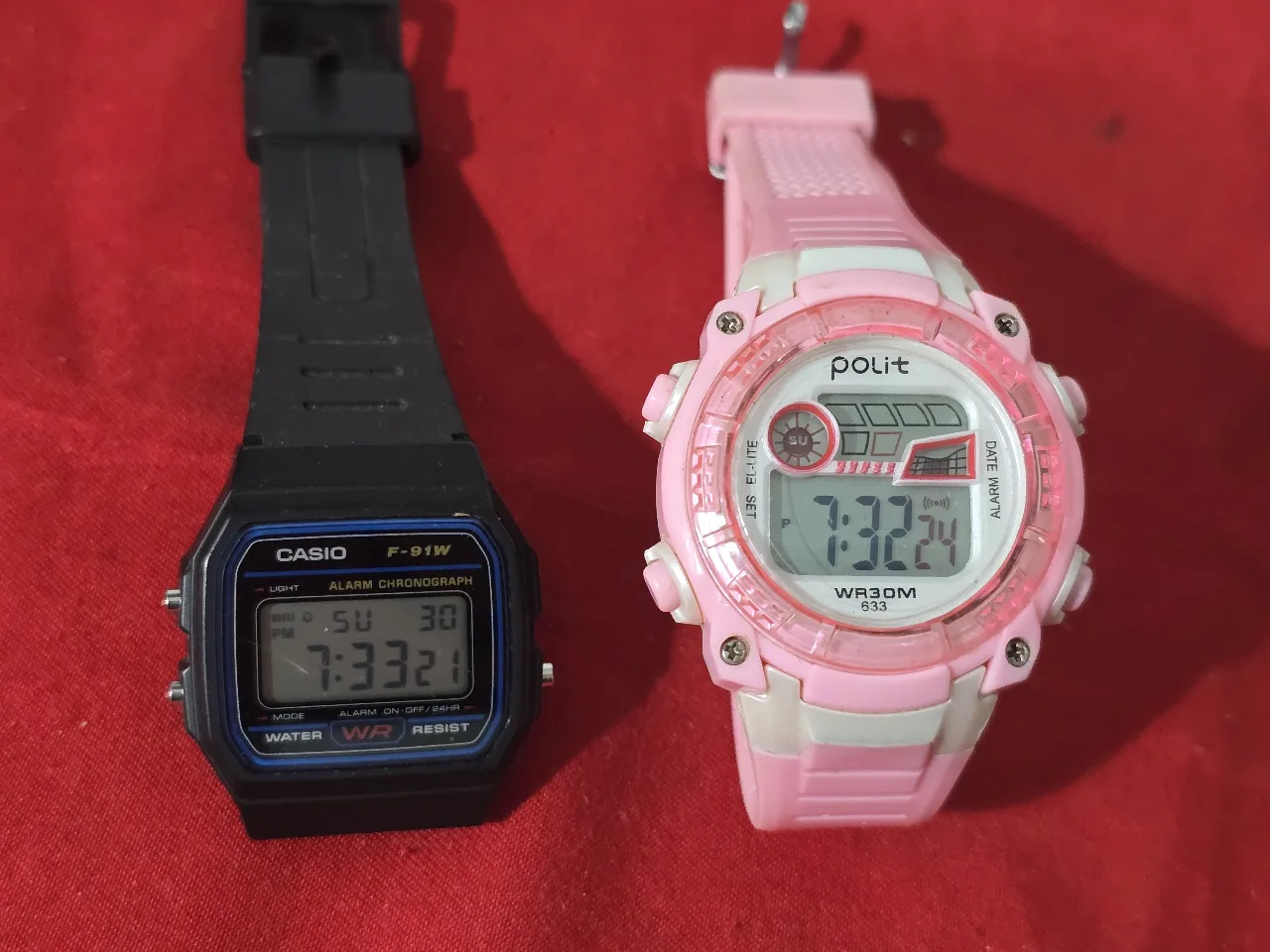 זוג שעונים דגיטלים שחור וורוד השחור זה שעון קסיו שנהם במצב עבודגה