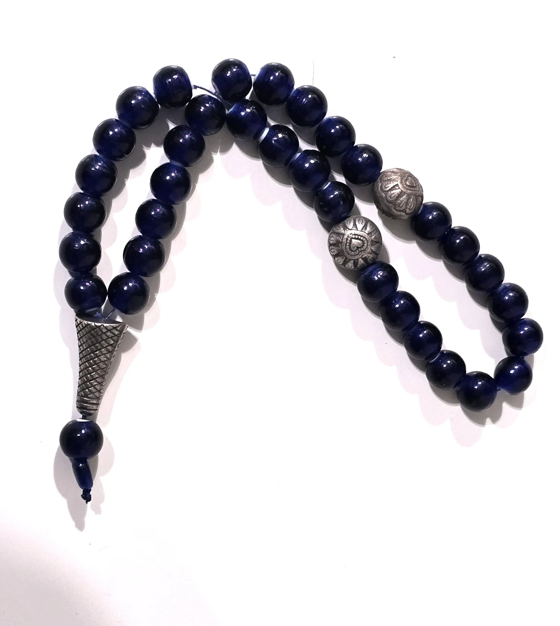 מחרוזת תפילה איסלמית מאסבחה בעלת 33  חרוזים צבע האבן כחול עמוק החרוזים אבני לאפיס .המחרוזת מעוטרת באלמנטים של כסף