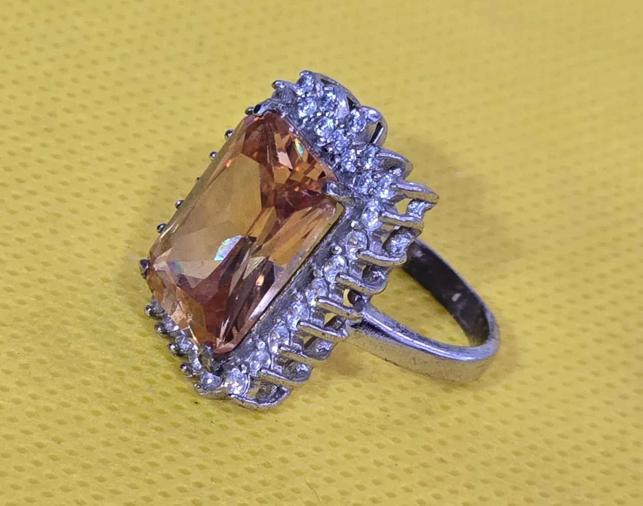 טבעת כסף מרהיבה, משובצת אבן סיטרין כתומה ומסביבה זירקונים.אבני סברוןבסקי חתומה 925. משקל כולל: 8.42 גרם. מידת הטבעת: 7.