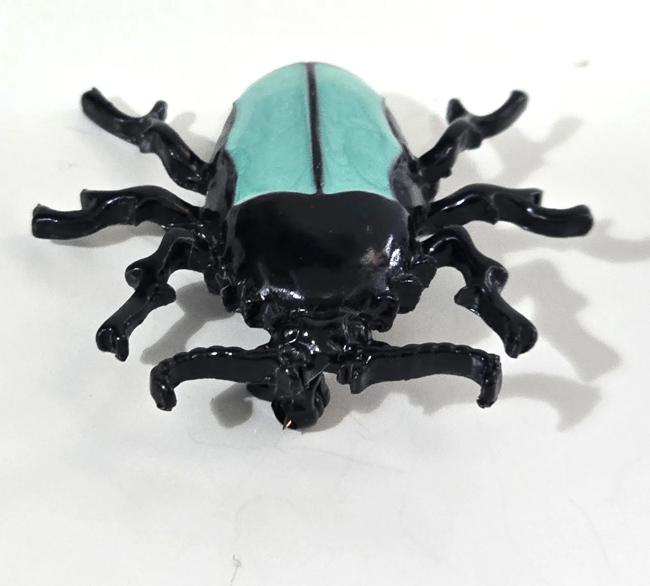 סיכת חרפושית - מתכת שחורה עם גב סברובסקי בצבע טורקיז אורך 3.5 ס"מ