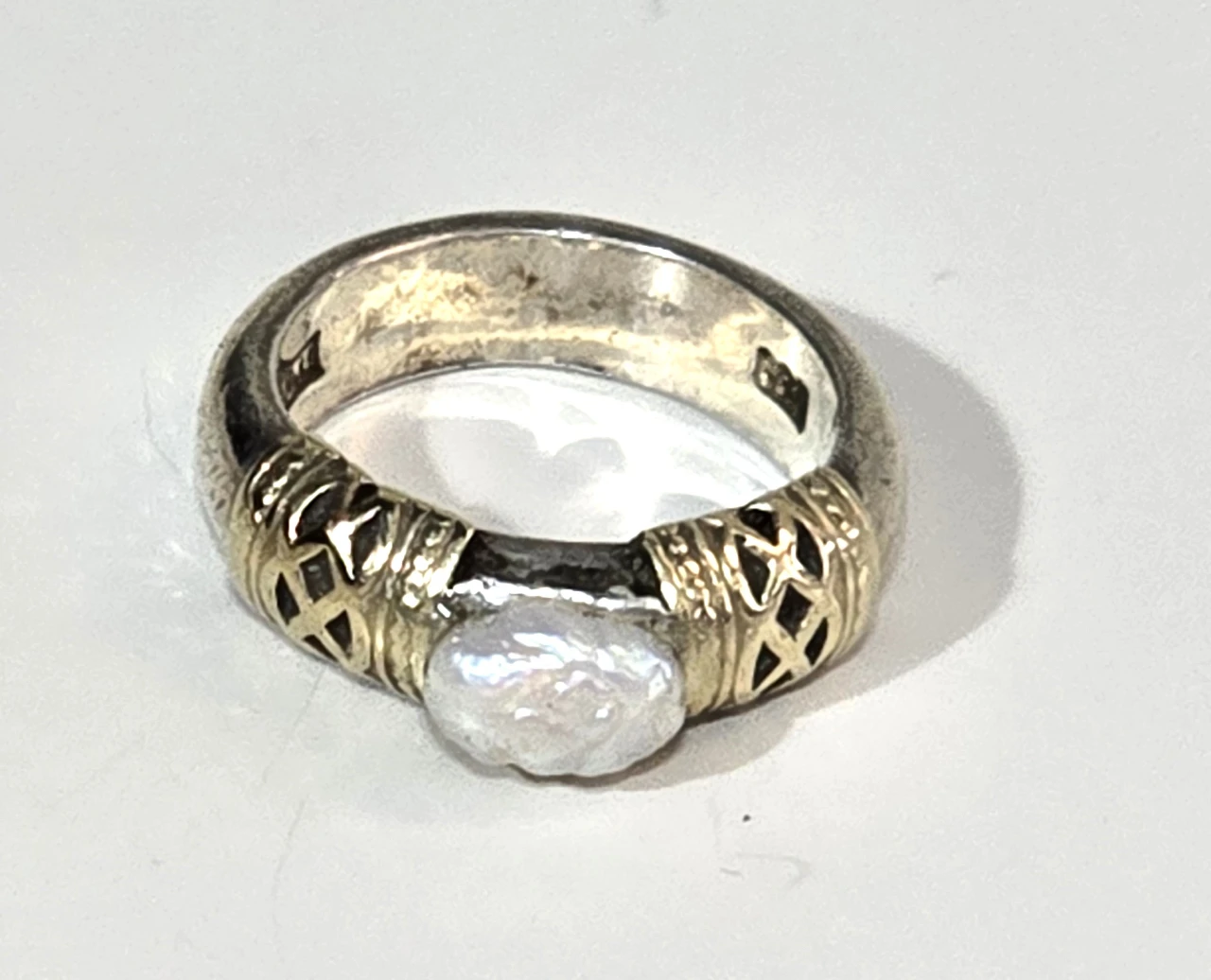 טבעת כסף 925 חתומה במרכזה פנינה לבנה ובצידי האבן נגיעות של זהב וינטג' יפה ואיכותית. מידה: 6 משקל: 8 גרם