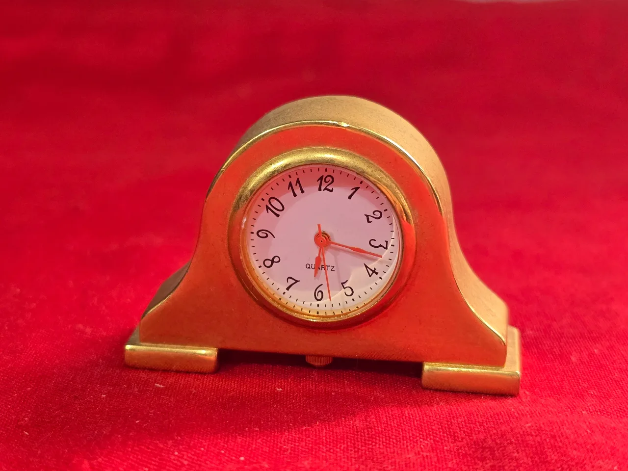 שעון מדף מיניאטורי איכותי עשוי ממתכת איכותית מוזהבת. מנגנון קווארץ איכותי.  רוחב 5 ס"מ.  השעון לא ניבדק - כנראה החלפת סוללה.  מצב: 	טוב