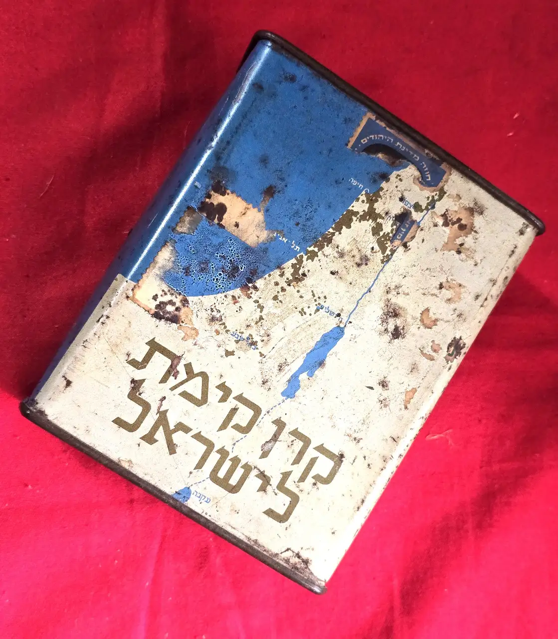 קופת צדקה - קרן קיימת לישראל    איור של מפת ישראל עם ציון של הערים הגדולות ודגל ישראל  14*9 סמ' תוצרת אלברט זלצמן ירושלים היחודי בקופה זו שעקבה מופיעה על המפה קופסה זו משנות ה.40\50