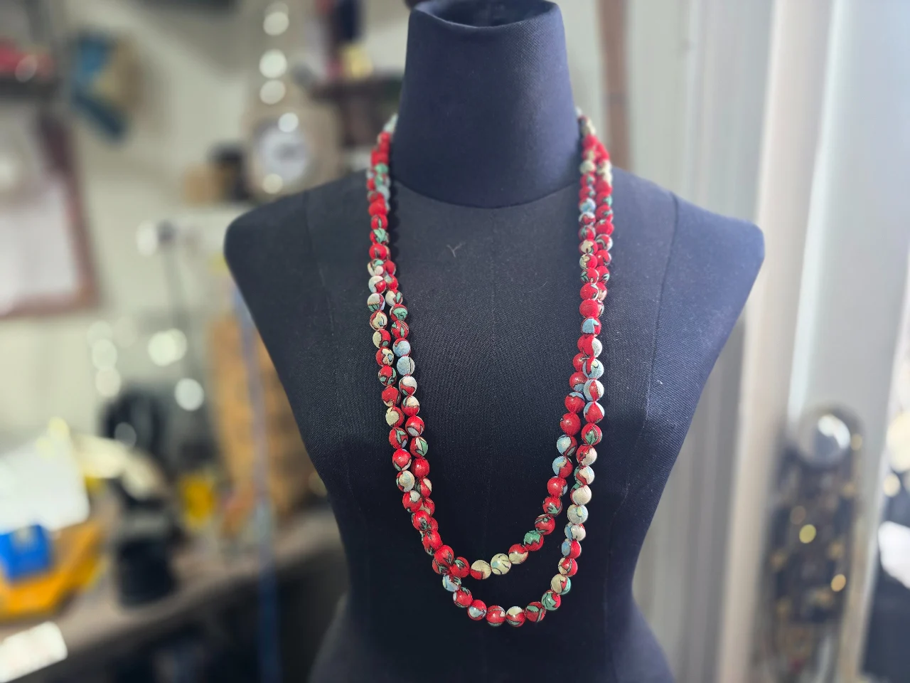 שרשרת ארוכה העשויה מחרוזי עץ שנעטפו בבד דק הפריט מעניין