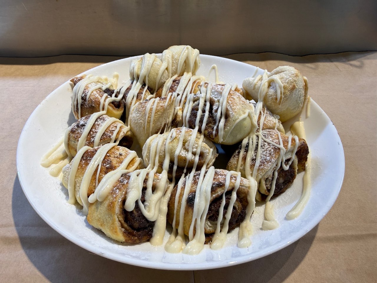 רוזלך קינמון - שכבות בצק רך שמתלפפות סביב חמאה סוכר חום וקינמון מטריף, בזילופי שוקולד לבן.