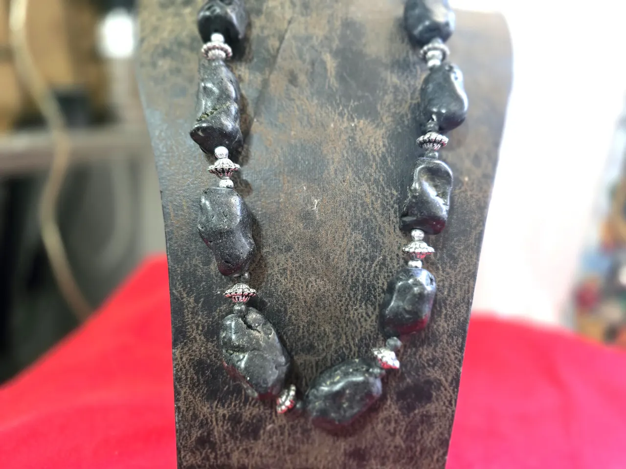 שרשרת מורכבת מאבנים שחורות גדולות וטבעיות המופרדות הנהם עם חרוזי כסף