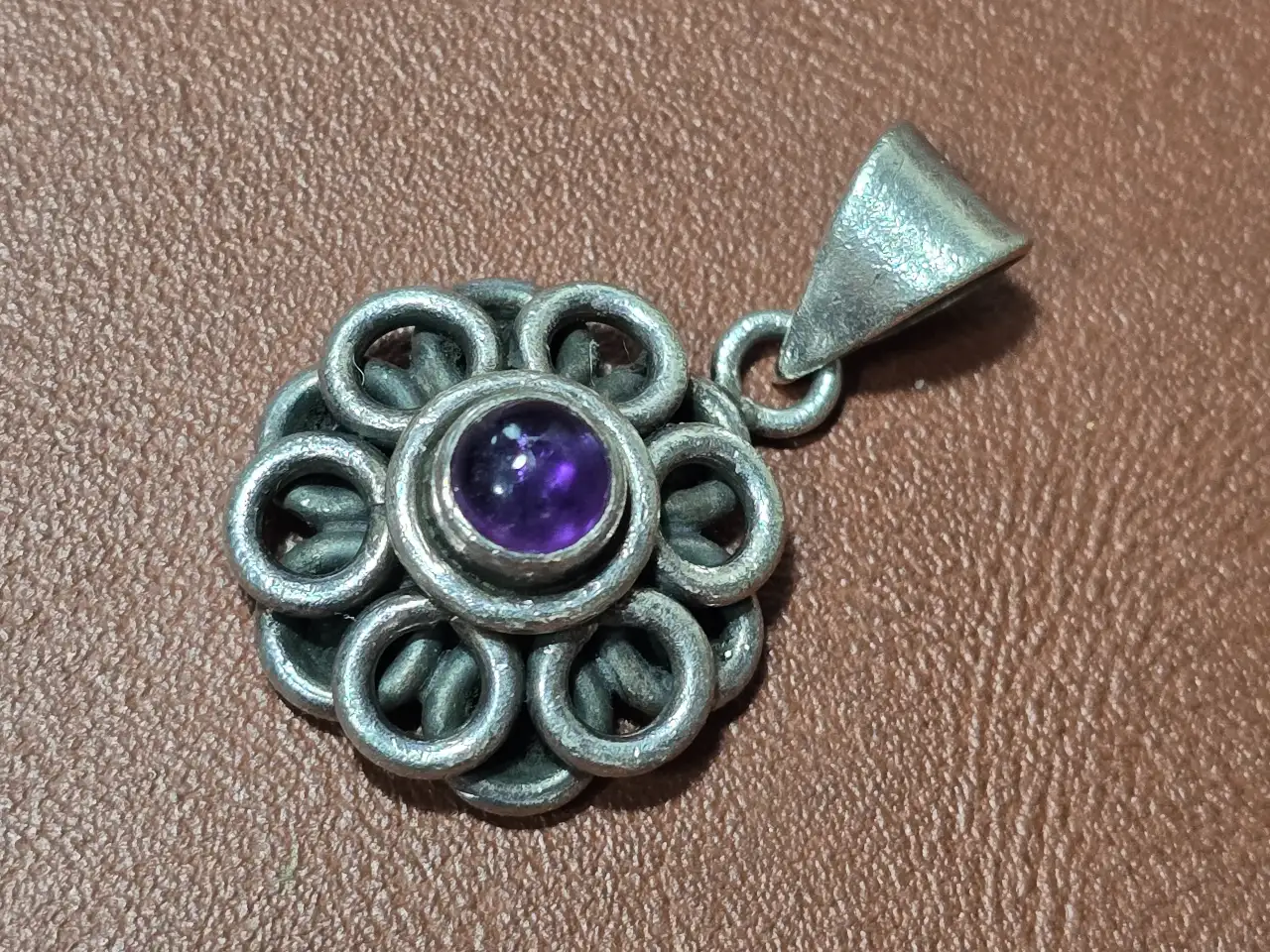 תליון כסף בדוגמת פרח משובץ אבן אמטיסט.  חתום 925.  משקל: 8 גרם.  אורך: 3 ס'מ.