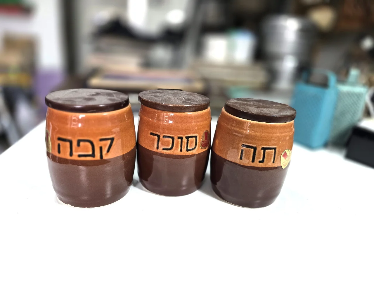 סט 3 מיכלי קרמיקה לסוכר, קפה ותה, עם מכסים מעץ, מידות 10/13 ס"מ  חתומים בבסיס ונושאים את מדבקת היצרן, בן פורת,  לא היו בשימוש.