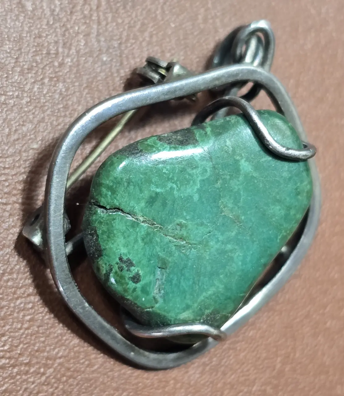 תליון שהוא גם סיכה אבן מאלכית ומתכת חובקת כנראה כסף נמוך