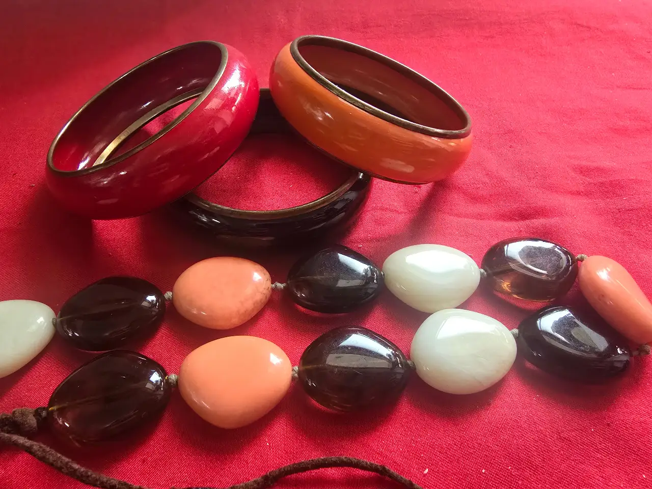 סט של תכשיטי אופנה בצבעים חמים 3 צמידים בצבעים אדום שחור וכתום השרשרת עשויה מחרוזים גדולים ושטוחים כמו חלוקי נחל וינט'ג שנות ה..70