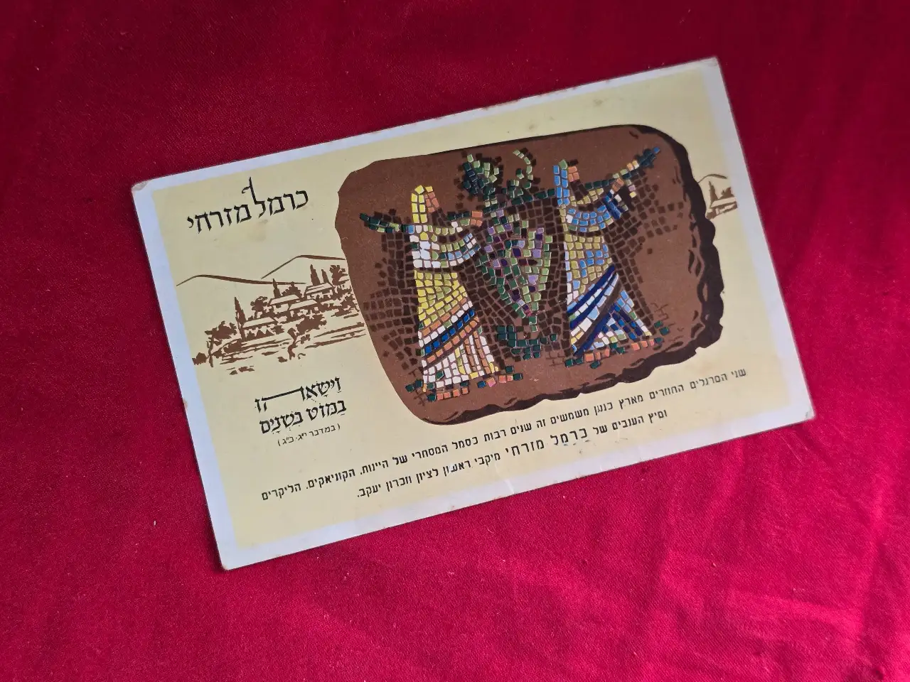 גלוית פרסומת של חברת המשקאות "כרמל מזרחי". בחזית איור של שני המרגלים השבים מלתור את ארץ כנען. "וישאוהו במוט בשנים" (במדבר, יג, כג). מאחור: "שיר המזג". משנות ה-60 של המאה הקודמת