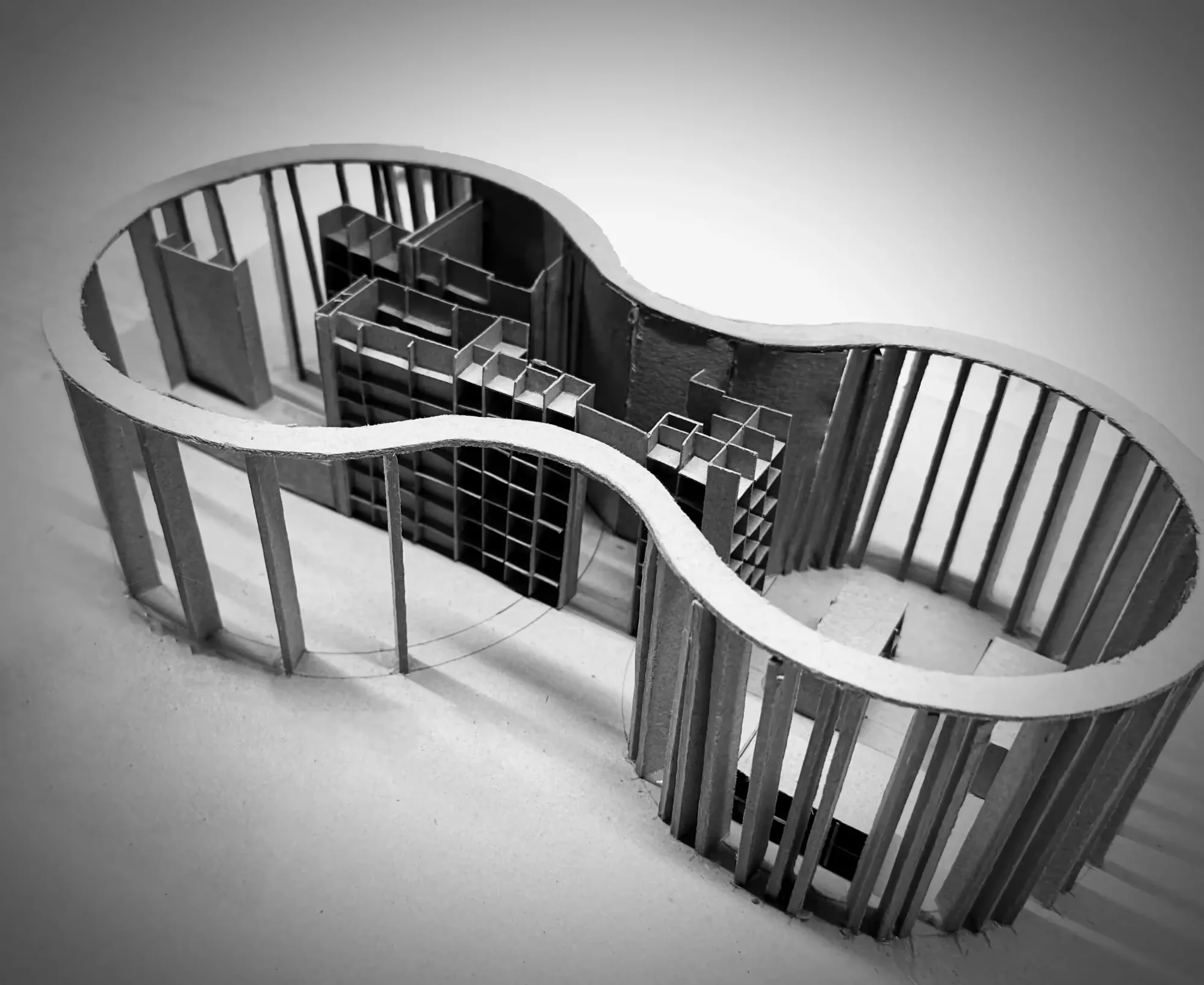 Modell: Hantelförmiger Pavillon aus Pappe mit sichtbarem Waffel-Regalsystem und Lamellenfassade.