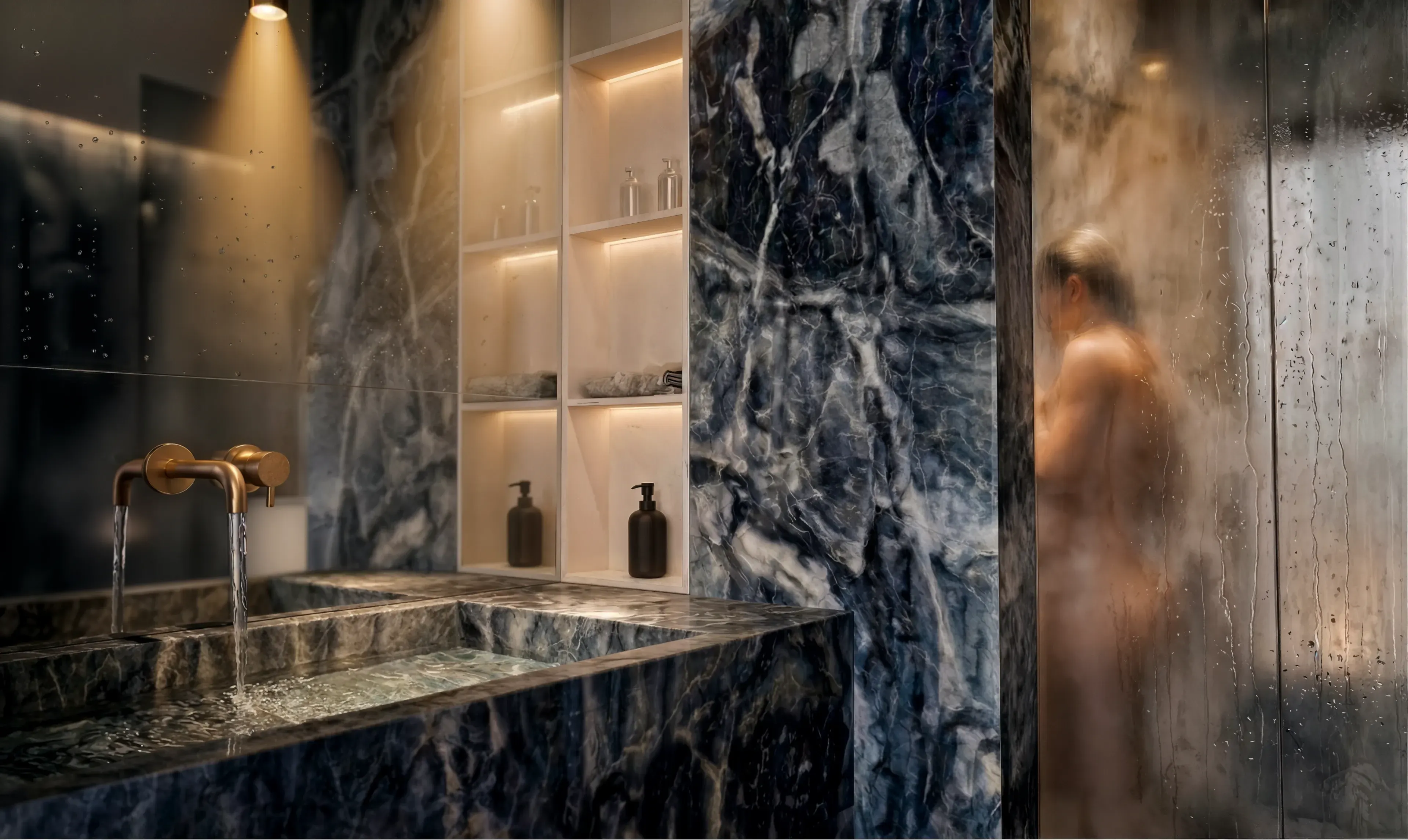 Waschplatz aus tiefblauem Marmor mit integrierter Beleuchtung und nasser Glasdusche.