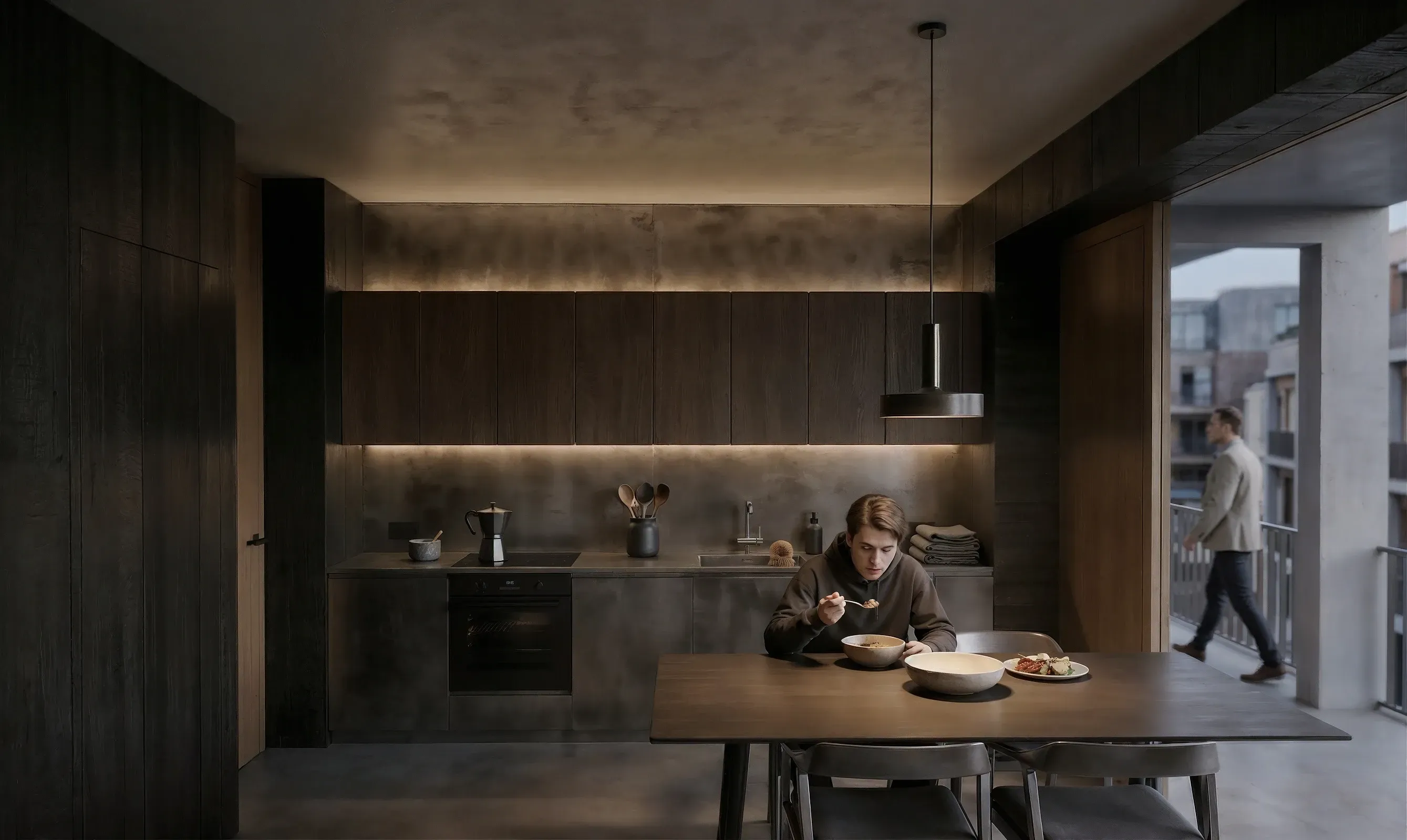 Innenansicht einer 40m²-Wohnung: Minimalistische dunkle Küche, Sichtbetonwände und fließender Übergang zum Balkon.