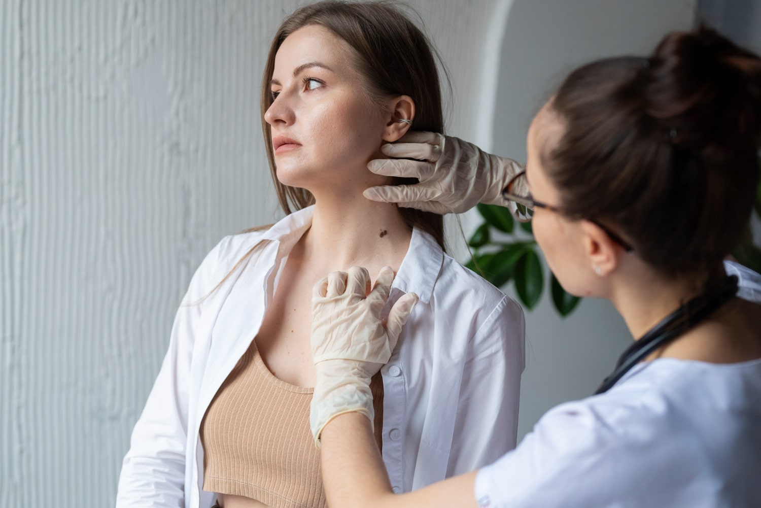 Close-up of a painless round lump on the skin behind someone’s ear.