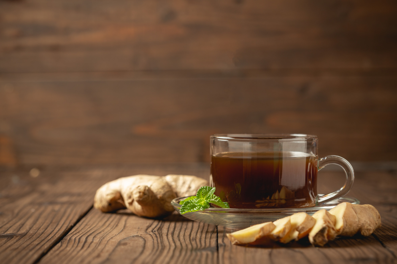 A cup of ginger tea with fresh ginger slices.