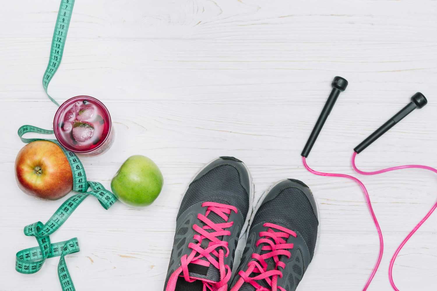A flat lay of healthy food, water, and workout shoes with a blood pressure monitor
