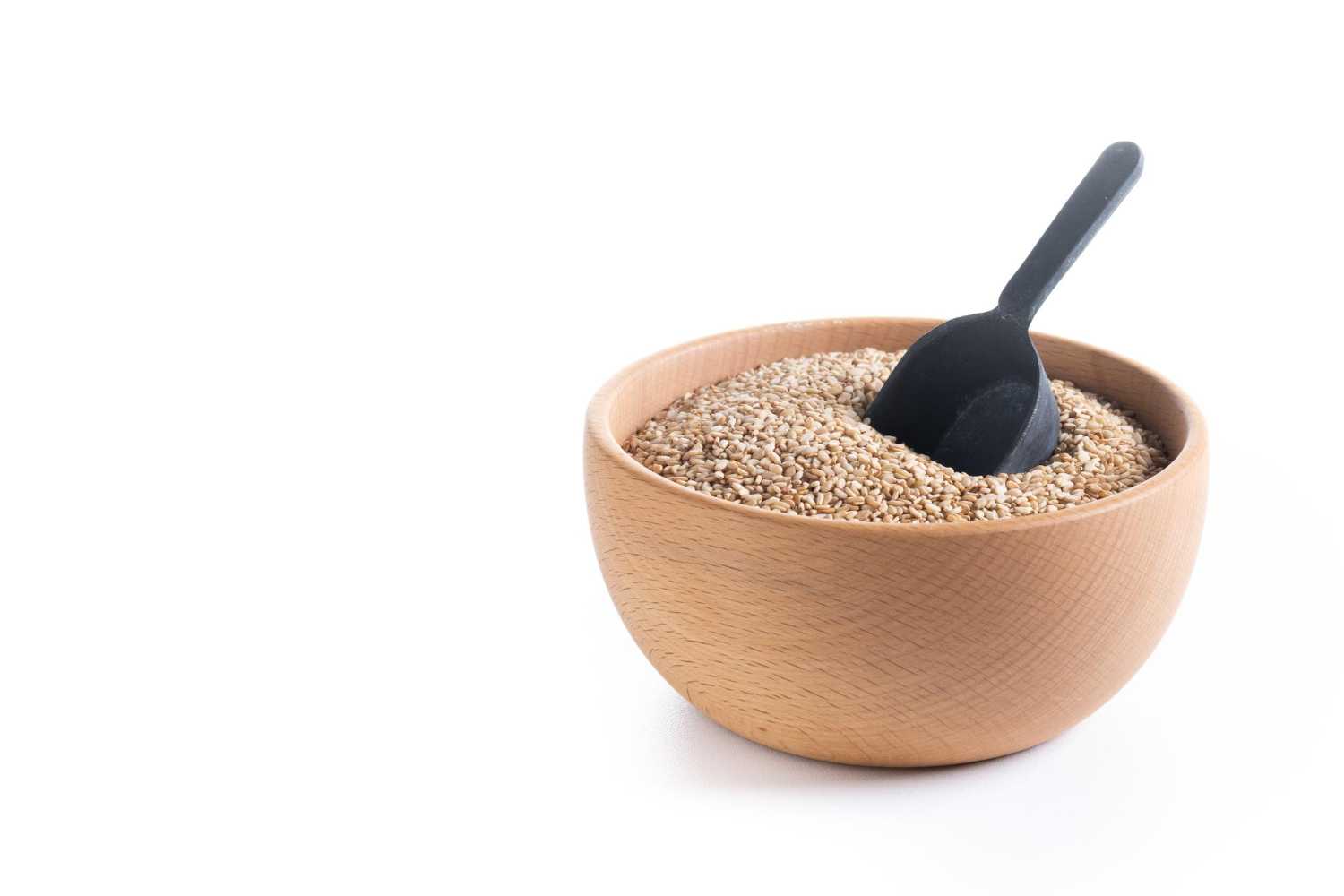 Sesame seeds in a bowl next to a blood pressure monitor.