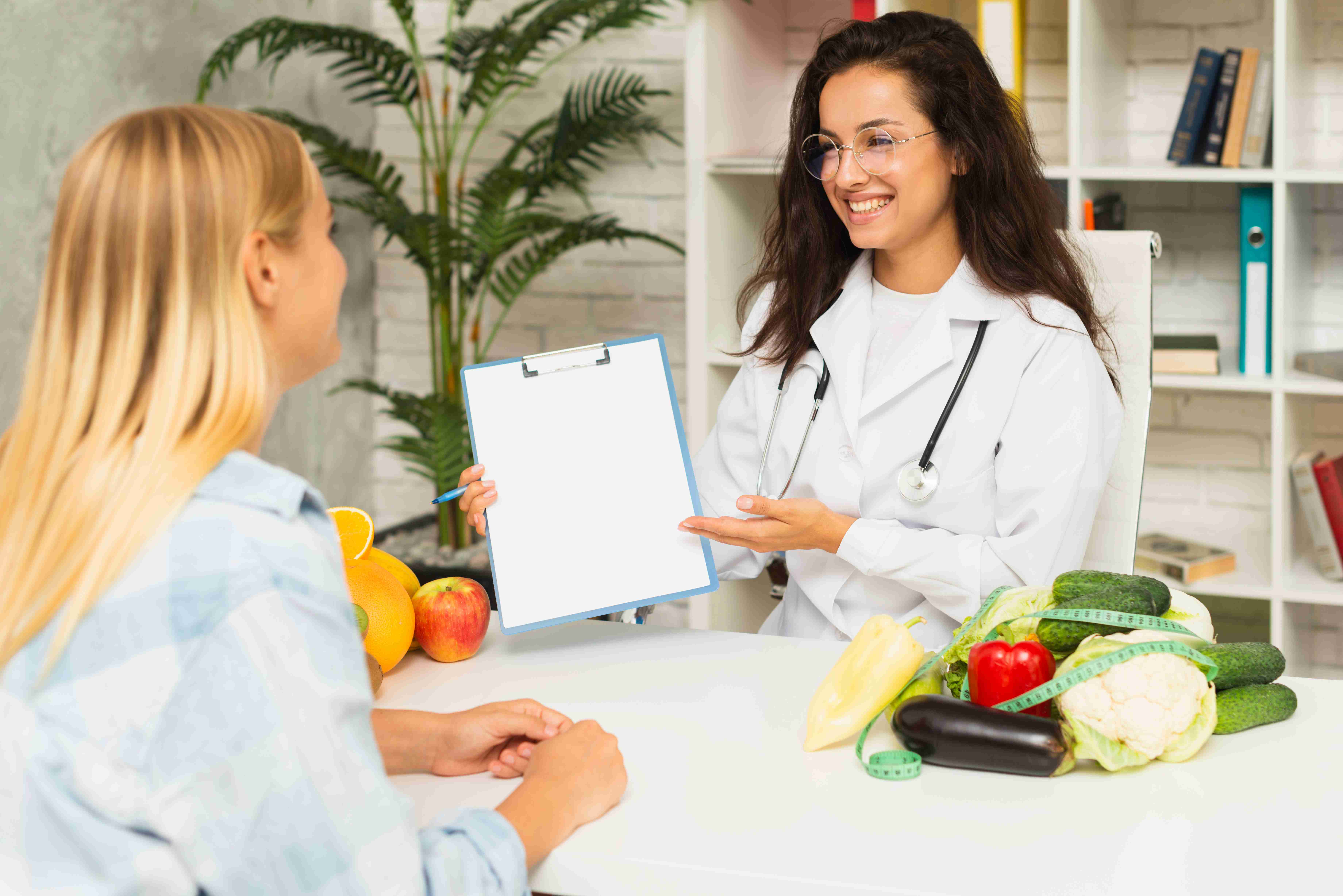 A nutritionist and a patient discussing a food chart together in a clinic setting.