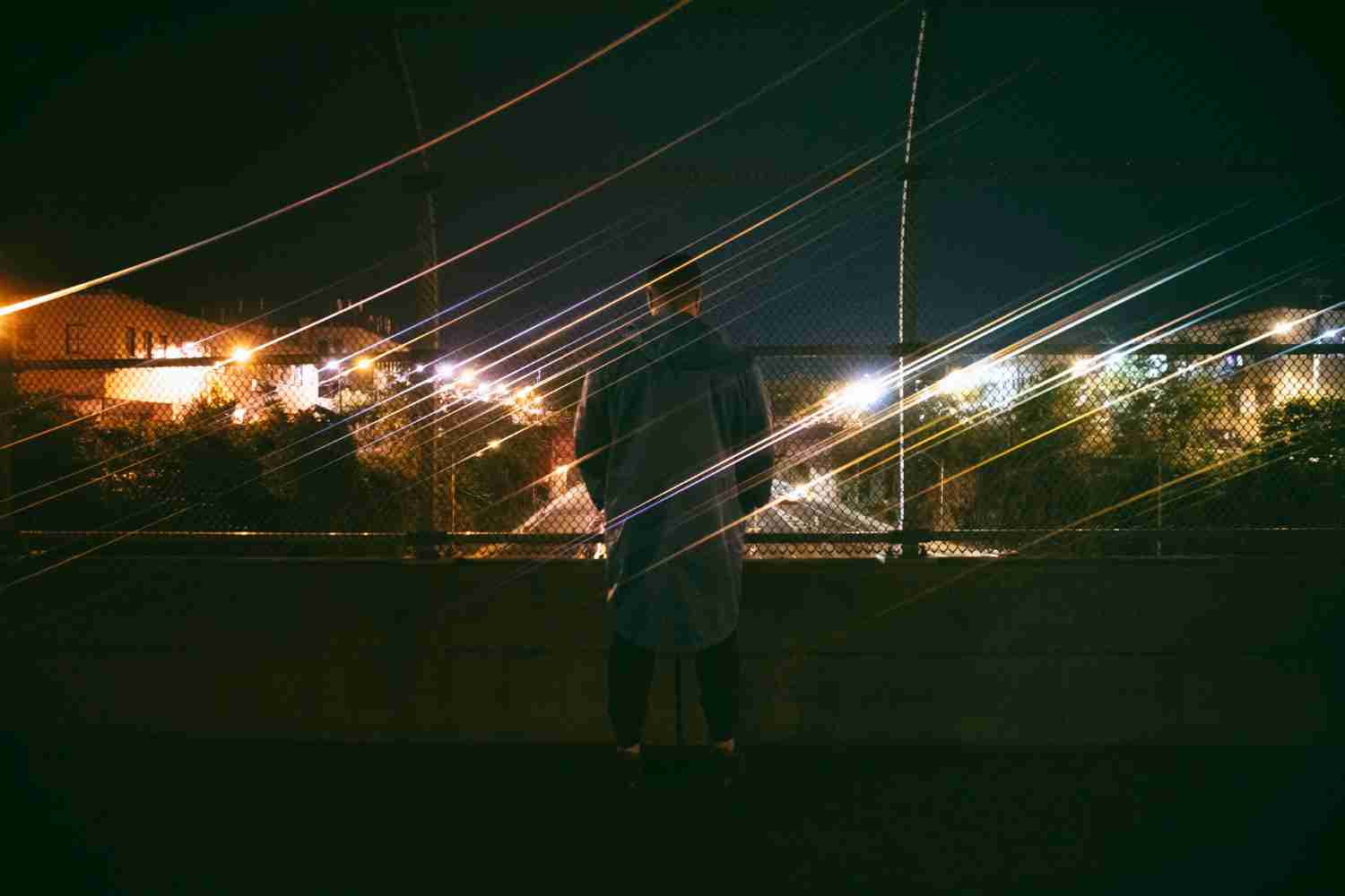 A person struggling to see at night, with blurred street lights in the background.