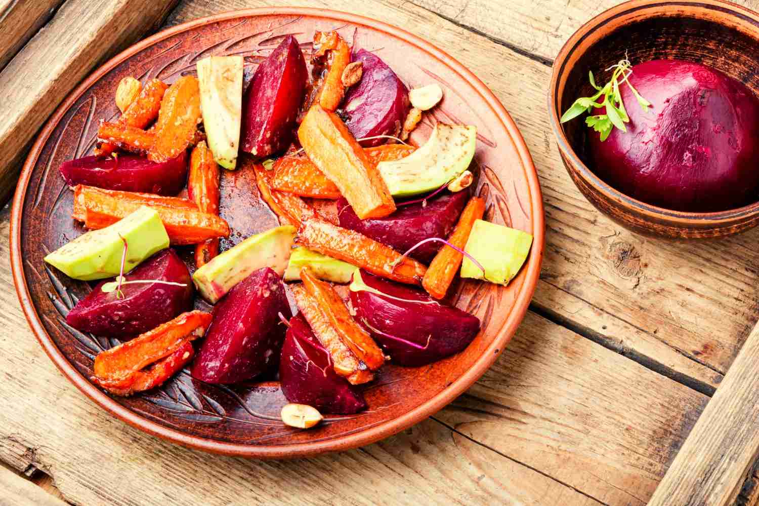 A colorful plate filled with leafy greens, sweet potatoes, grilled fish, and whole grains.