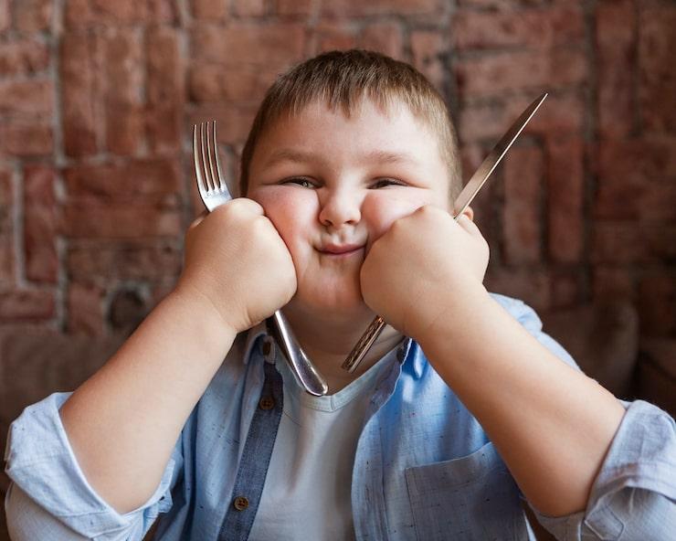 bored child with a knife and fork