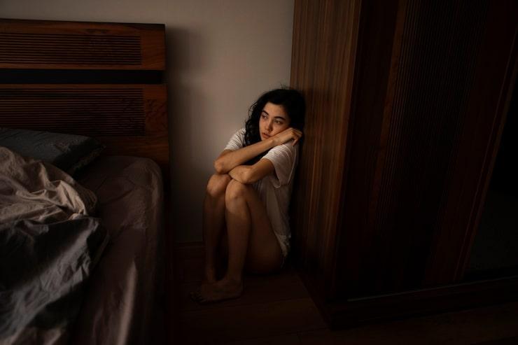 sad girl sitting curled up on the floor