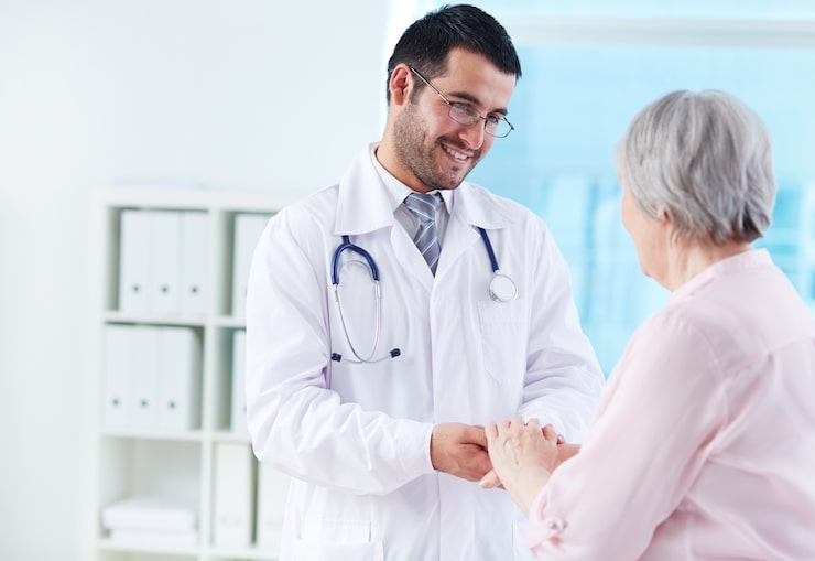 Doctor assuring Elderly patient of their recovery
