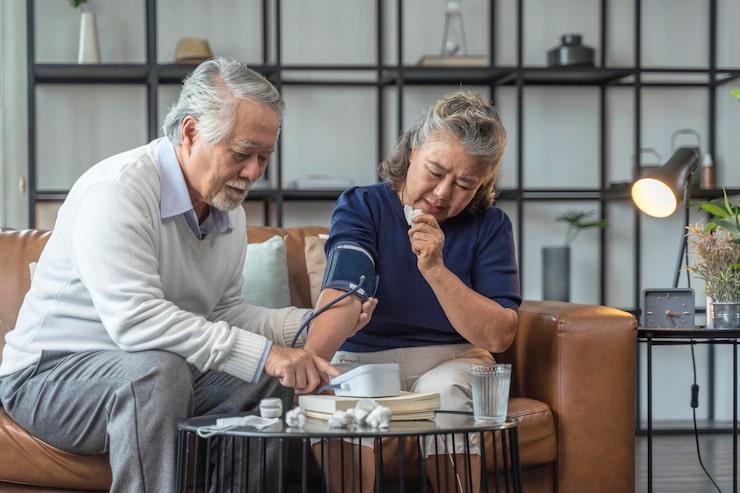 an elderly couple checking their blood pressure