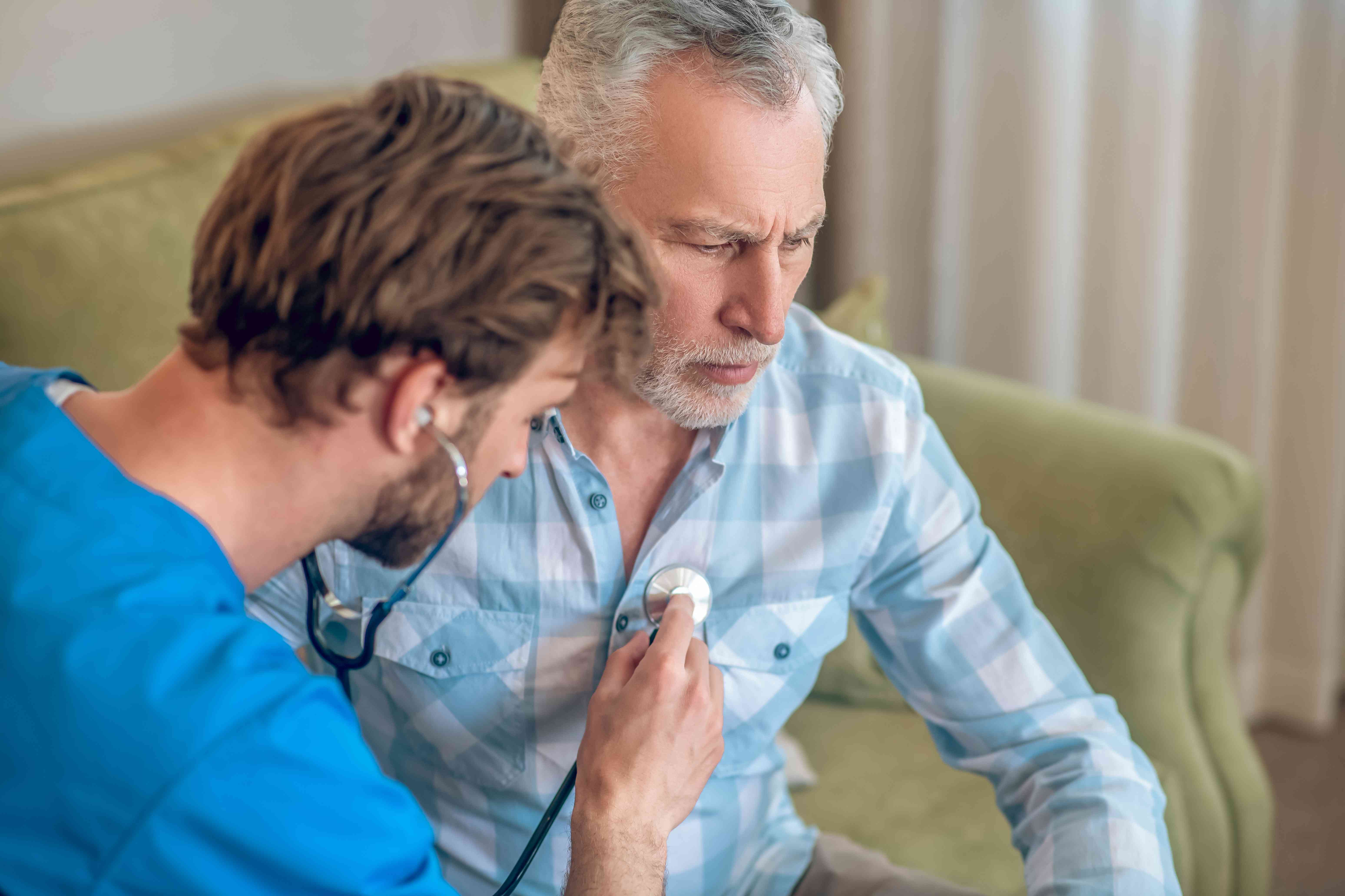 Alt text: A physician performing cardiac auscultation on an elderly patient.