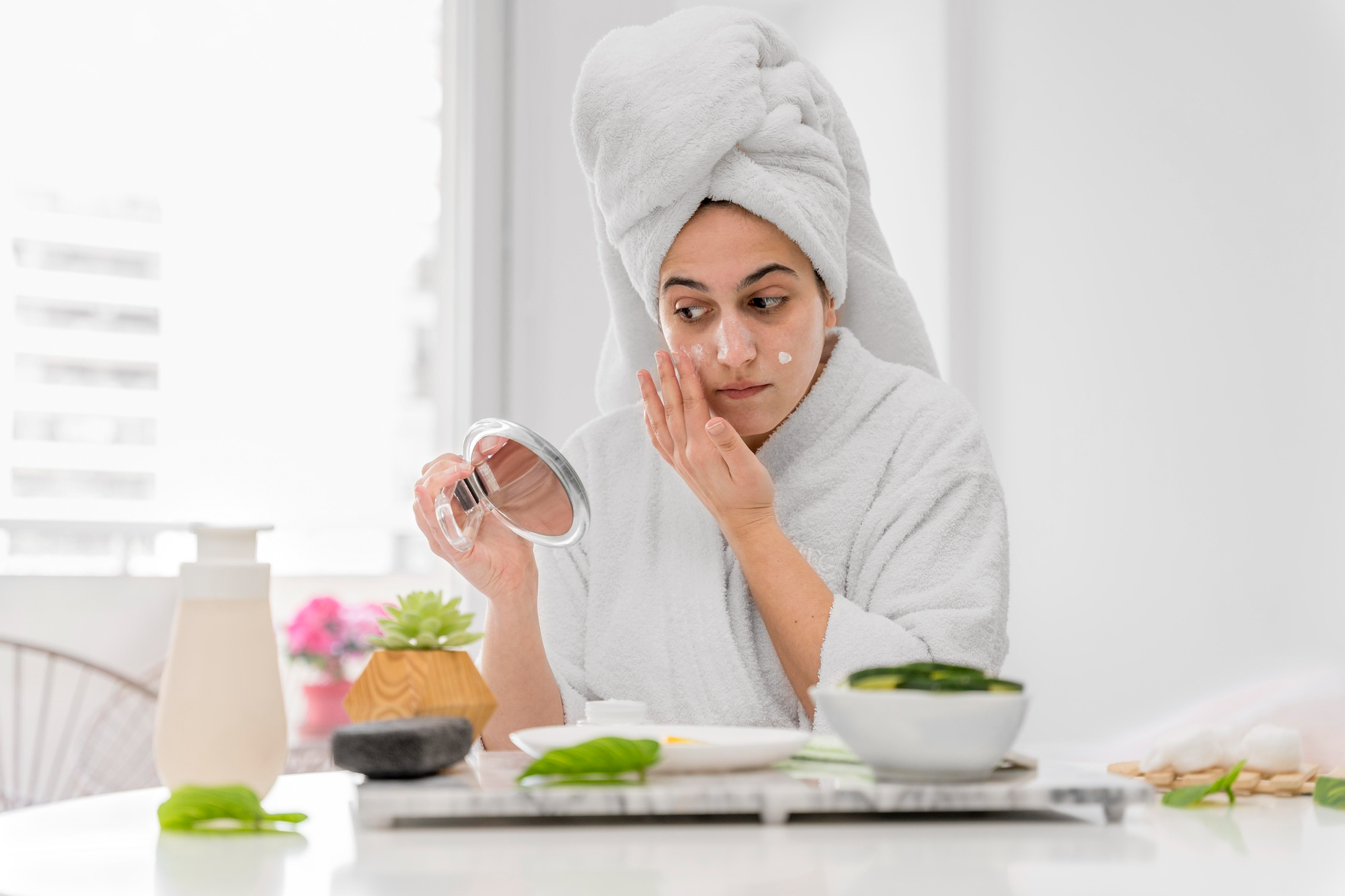 A woman applying a natural face mask made from home ingredients for glowing skin.