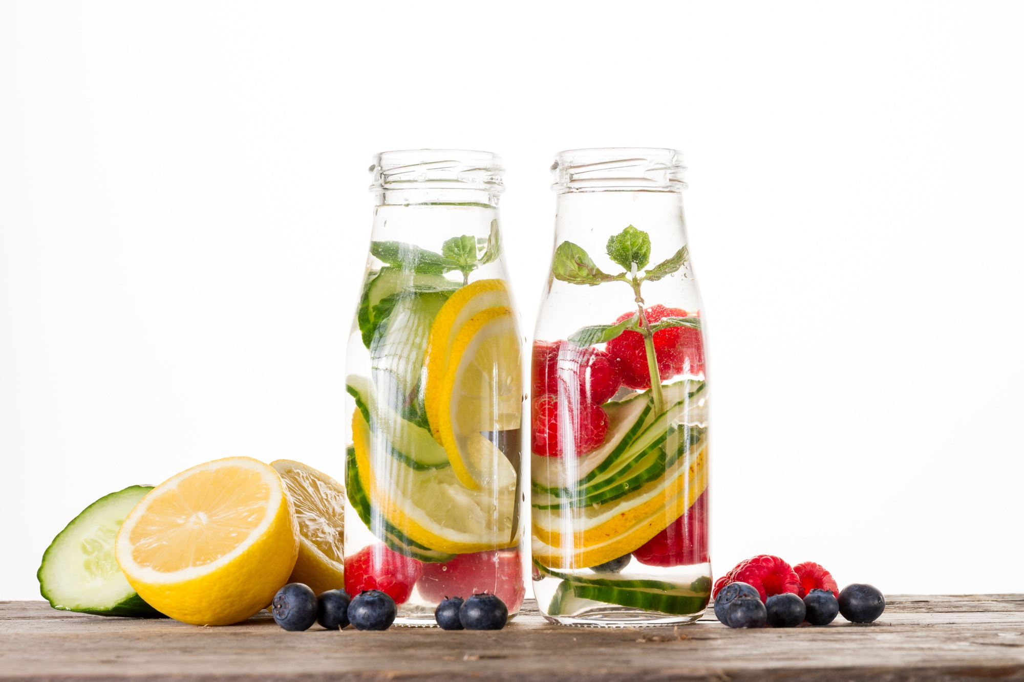 Fresh lemon, cucumber and mint slices floating in a glass jar of infused water, showing an easy and refreshing way to stay hydrated naturally.