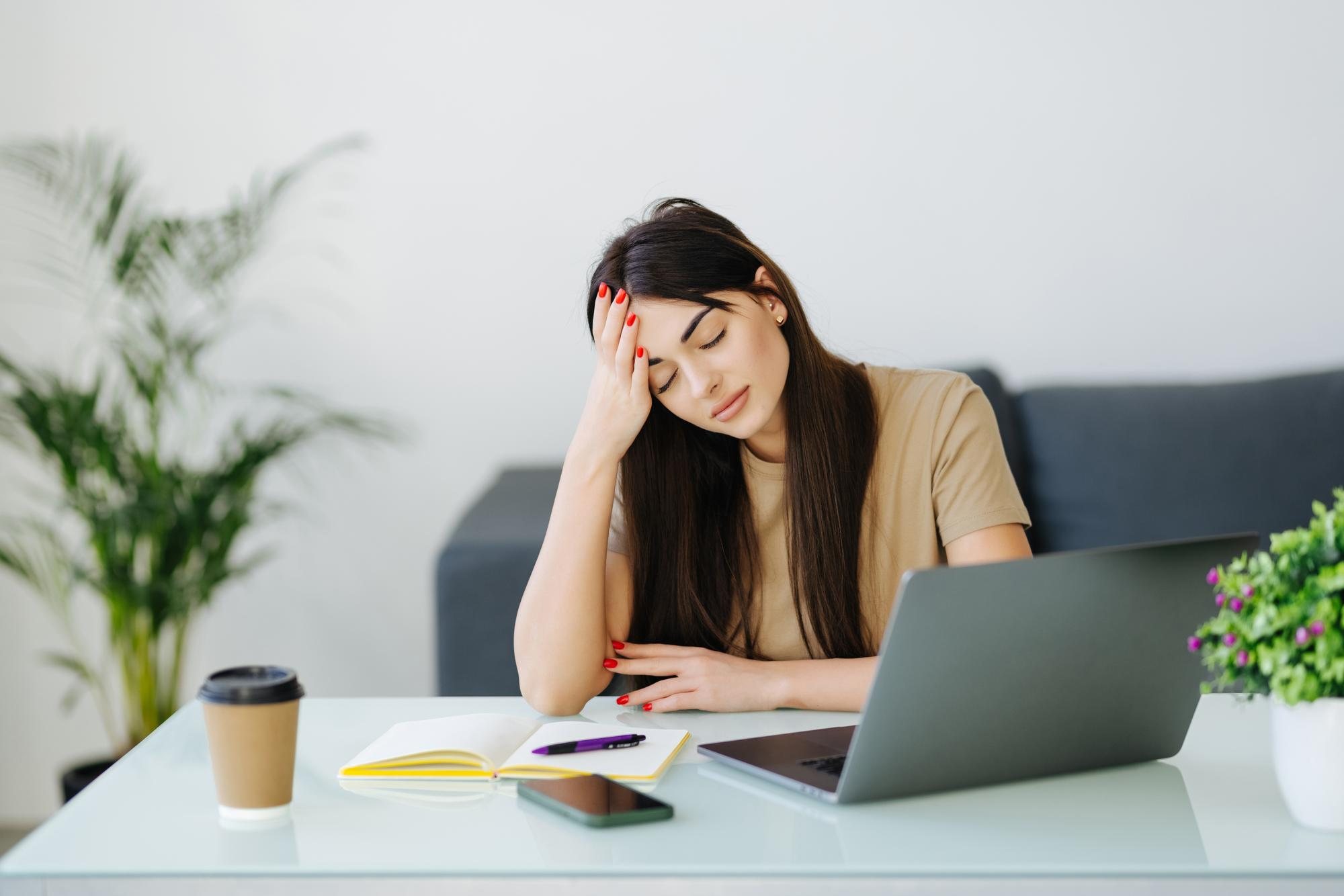 A woman appears exhausted and drained, sitting with her head resting on her hand highlighting persistent fatigue and low energy due to thyroid imbalance.