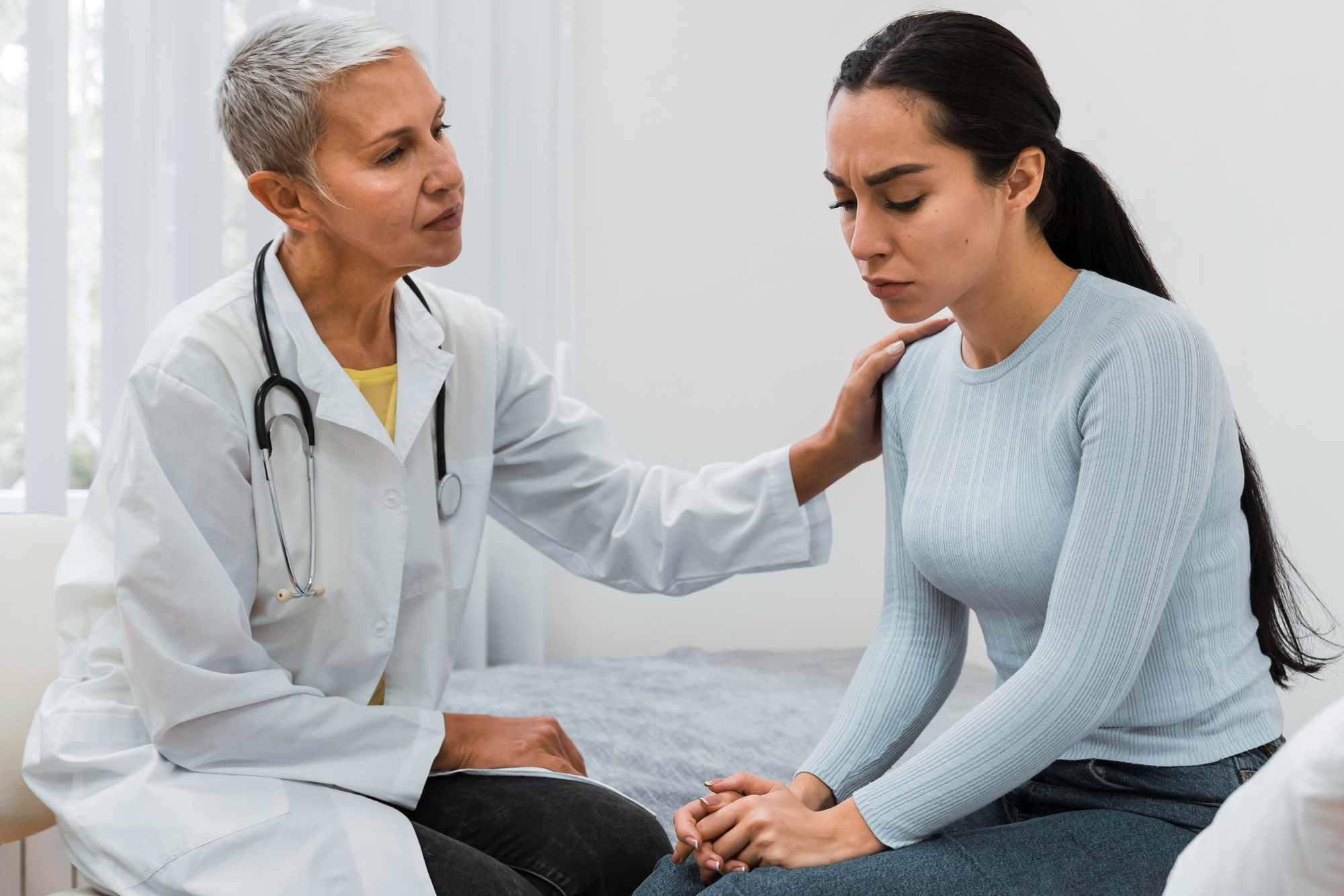A doctor sits beside a patient, listening with empathy and understanding which can help patients heal emotionally and physically, fostering a more holistic approach to wellbeing.