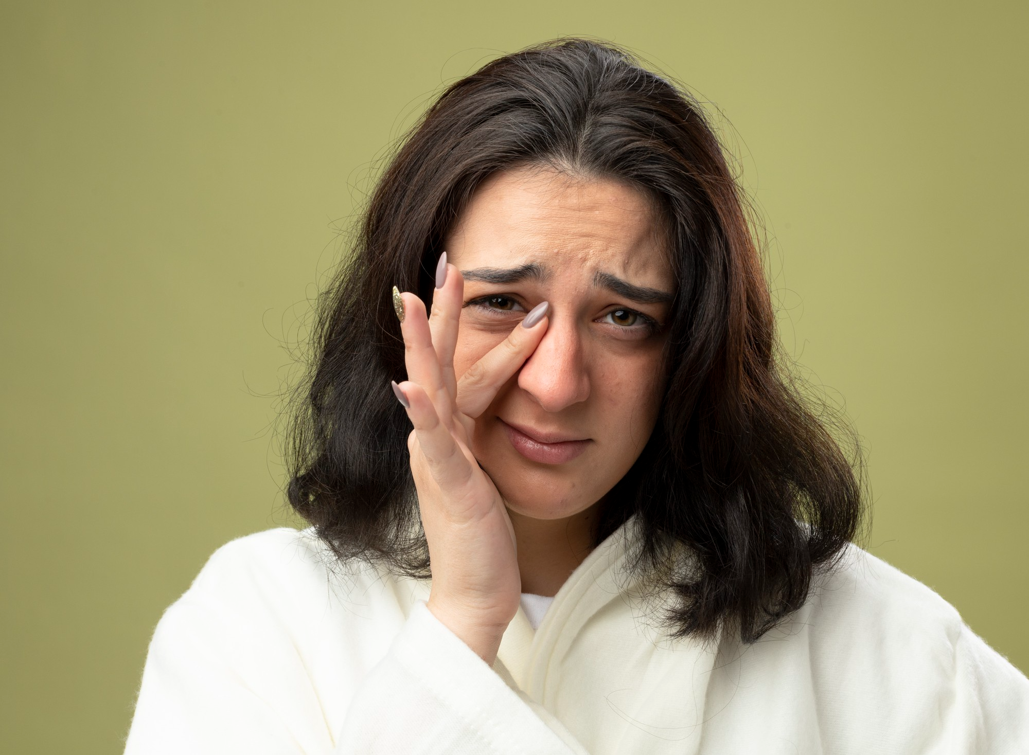A woman with dark circles and puffiness around her eyes, representing how lack of sleep, stress, or nutritional deficiencies can affect skin appearance.