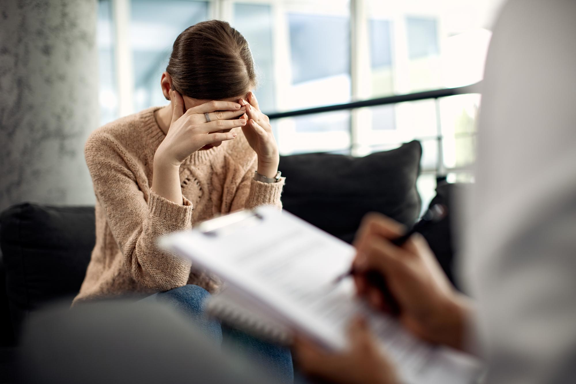 A person sitting with a doctor, appearing worried and tense, indicating stress and anxiety.