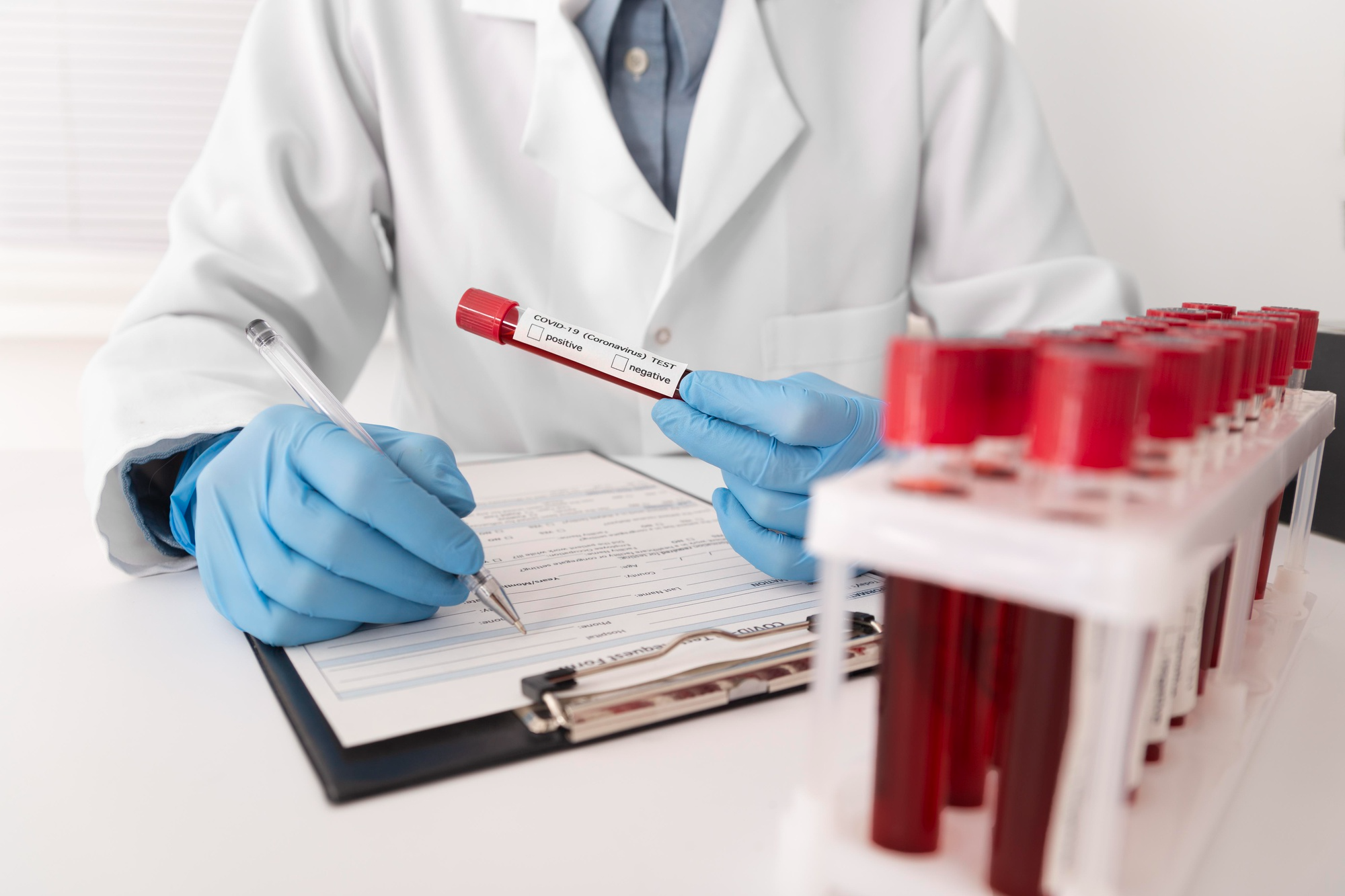 Medical doctor carefully observing a blood sample and recording findings, highlighting professional evaluation that supports accurate diagnosis and effective patient care.