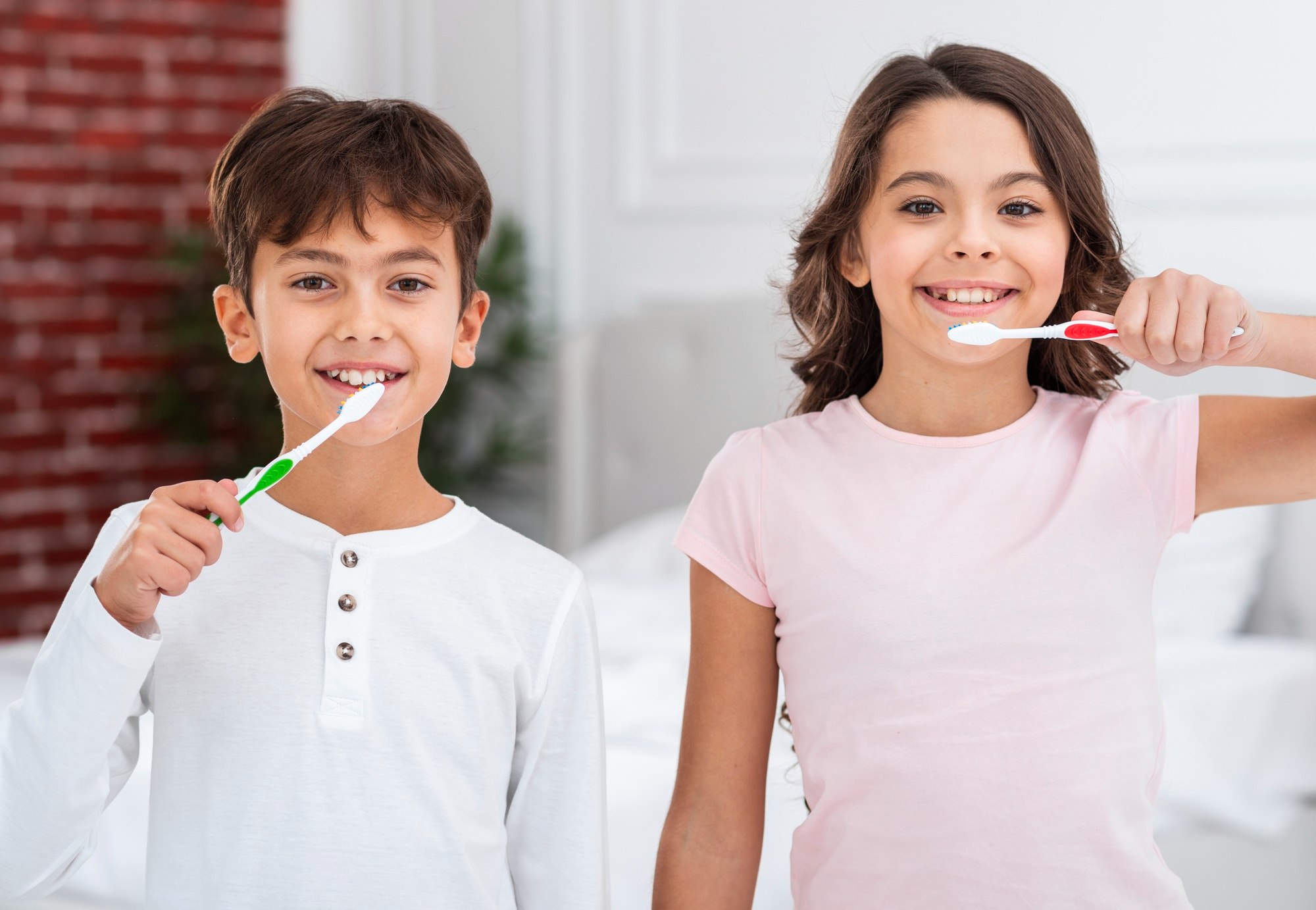 Two kids brushing their teeth, promoting healthy dental habits and the importance of daily oral care from an early age.
