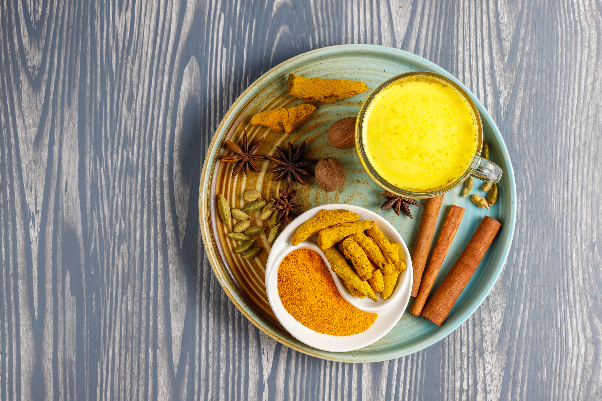 A display of vibrant spices including turmeric, cinnamon sticks and other colorful spices with health boosting properties.